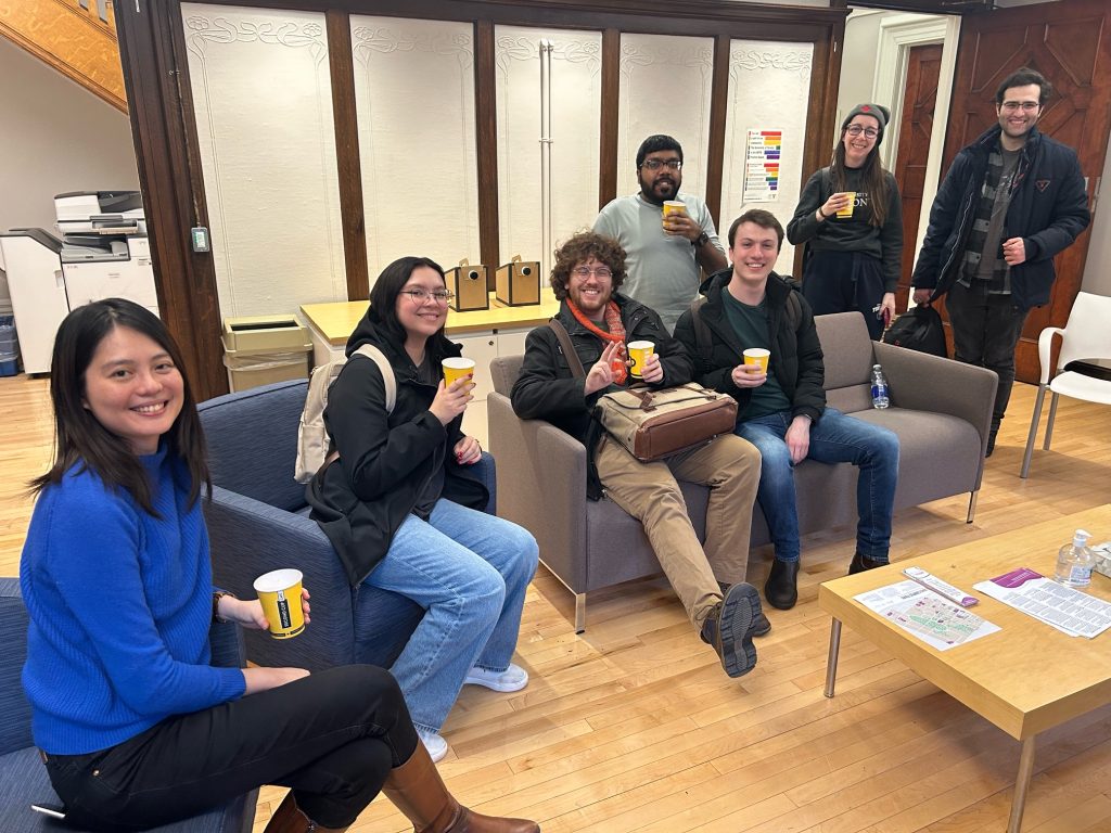 A group of students smiling and sitting in the SGS lounge.