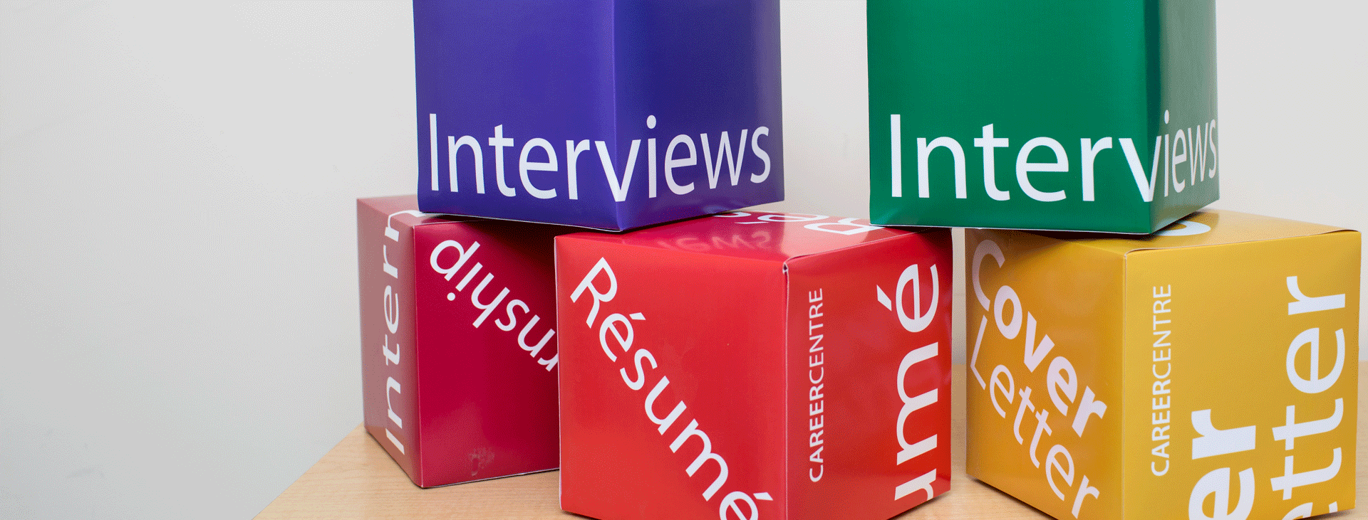Colorful cardboard cubes with text: interviews, resumes, cover letters