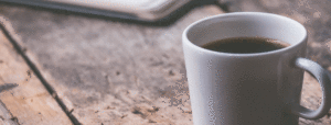 Cup of coffee in white mug on wooden table