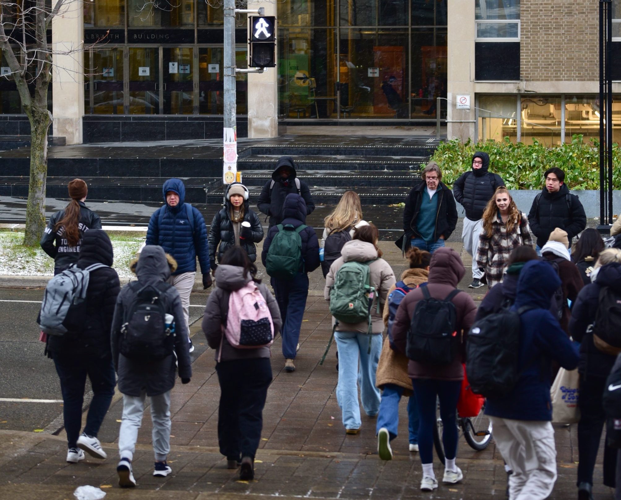 Students crossing the St. George Street intersection in front of the Bahen Centre and Galbraith Building on a chilly day.