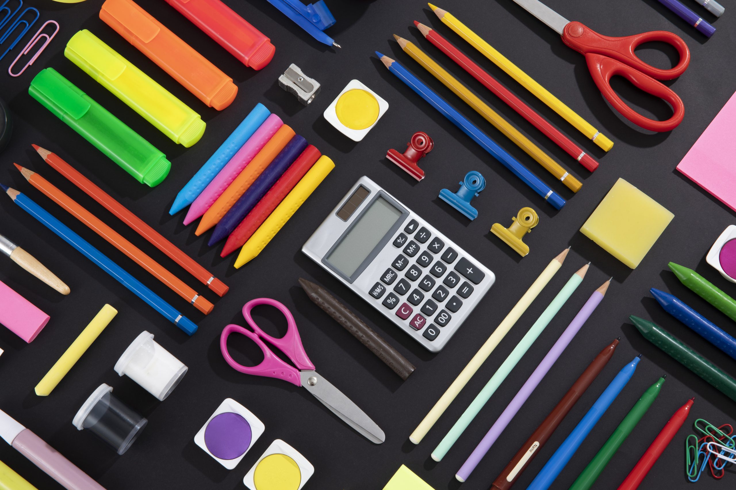 Back to school concept with school supplies knolling on black background