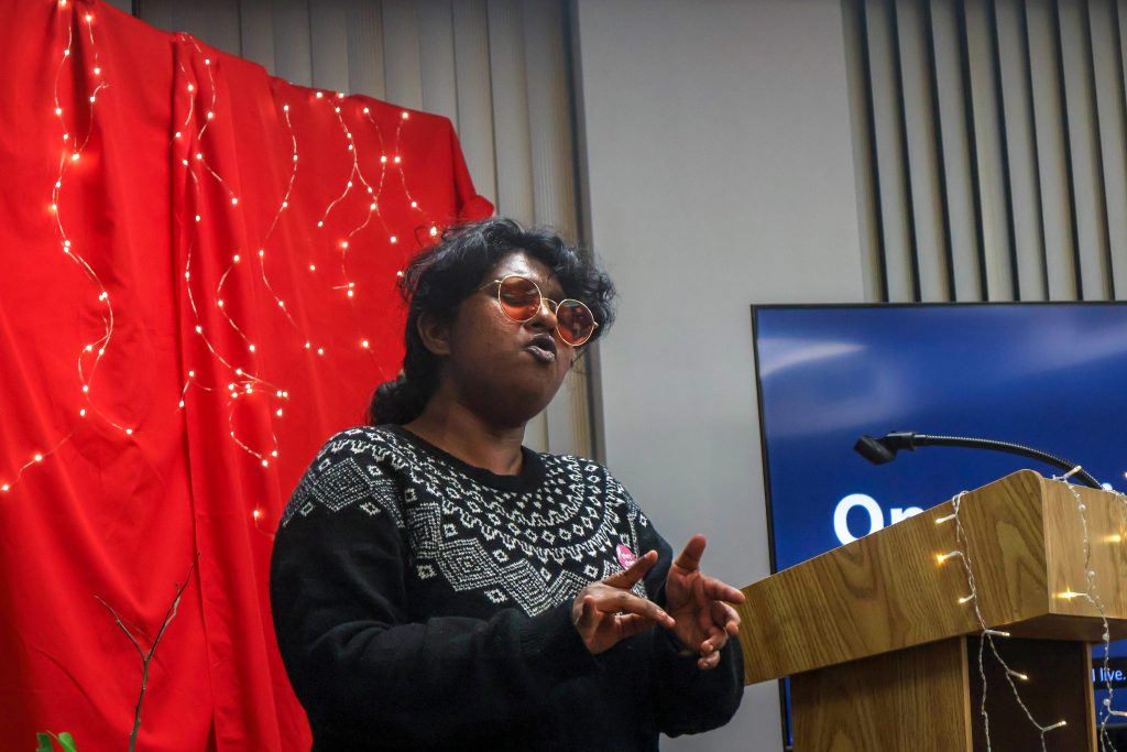 A student gesturing both their hands forward as they perform their piece.