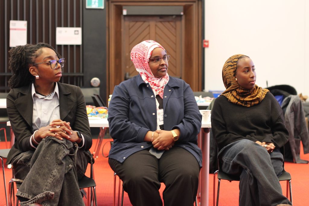 3 people sitting and listening while looking in the same direction.