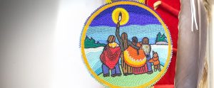 First Nations House mural beaded on a medallion.