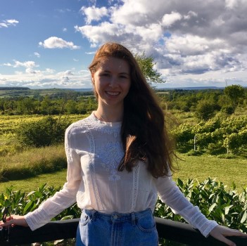 Niamh standing in front of an open field smiling.