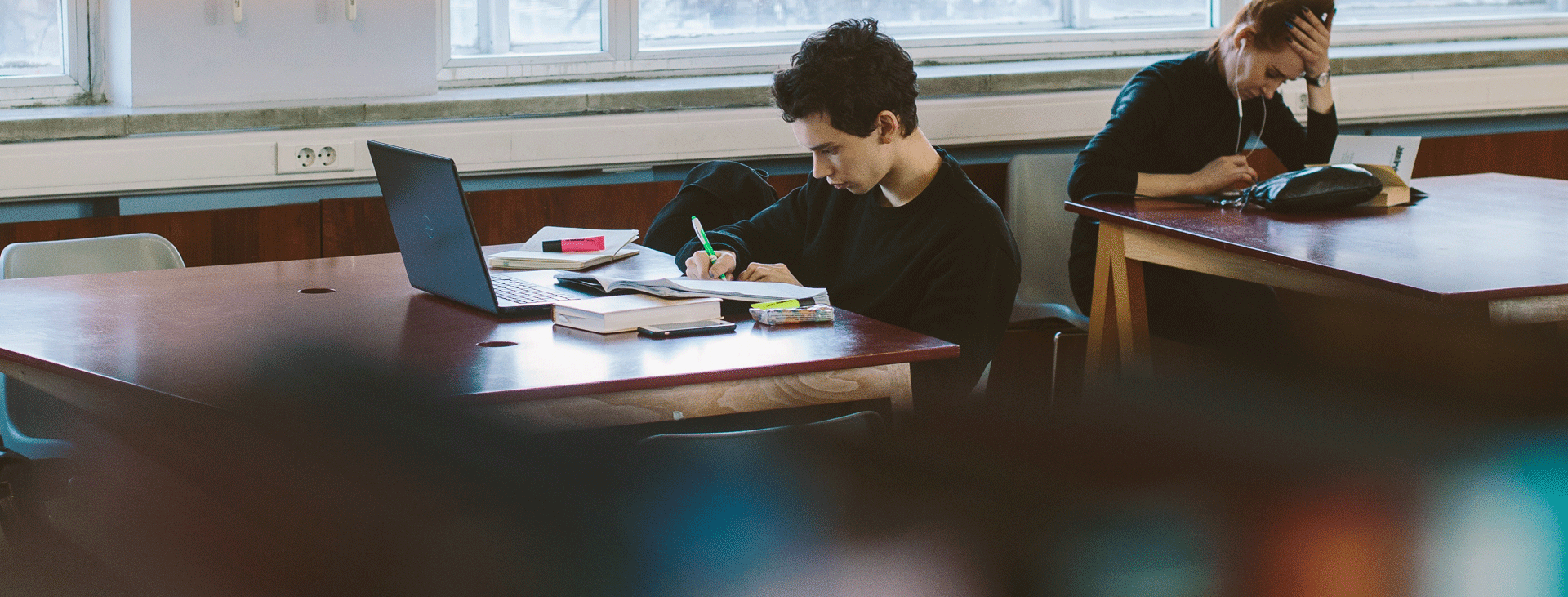 Two students studying at tables