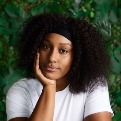 Anyika resting her face in her palm and smiling.