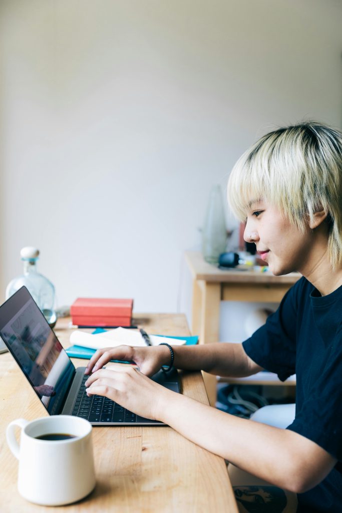 Student at a desk, looking at computer with hands over keyboard