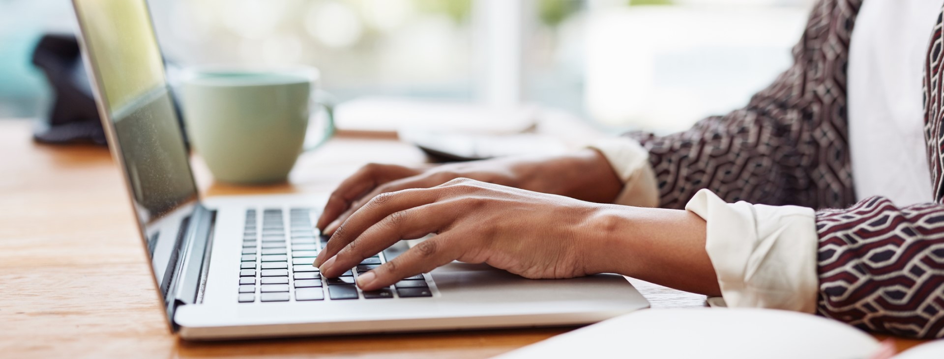 Person typing on a laptop keyboard.
