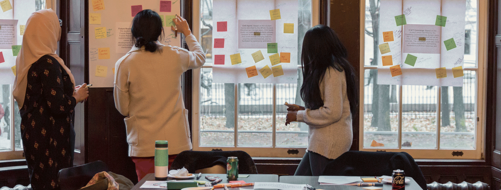 Three students design thinking with post it notes