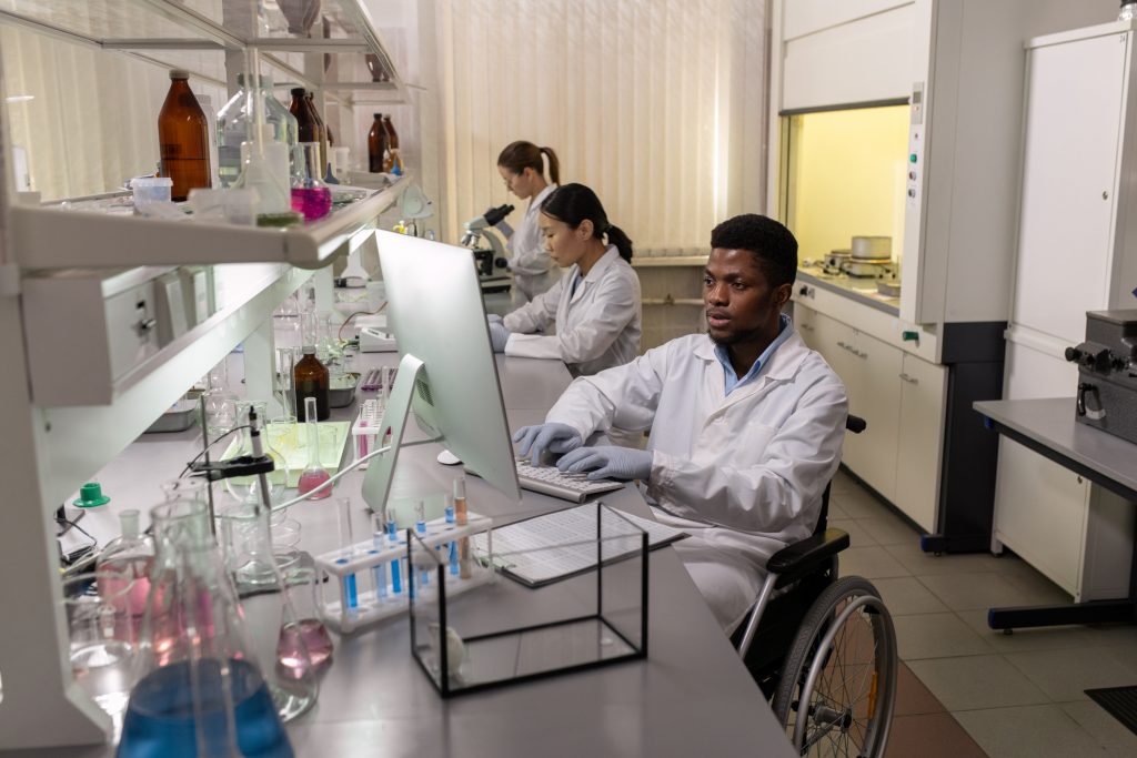 Wheelchair user working in science lab with colleagues