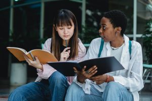 Two young women in discussion over books