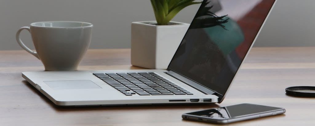 Silver Laptop and White Cup on Table